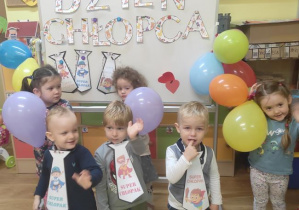 Dzieci z balonami stoją z balonami na tle dekoracji .